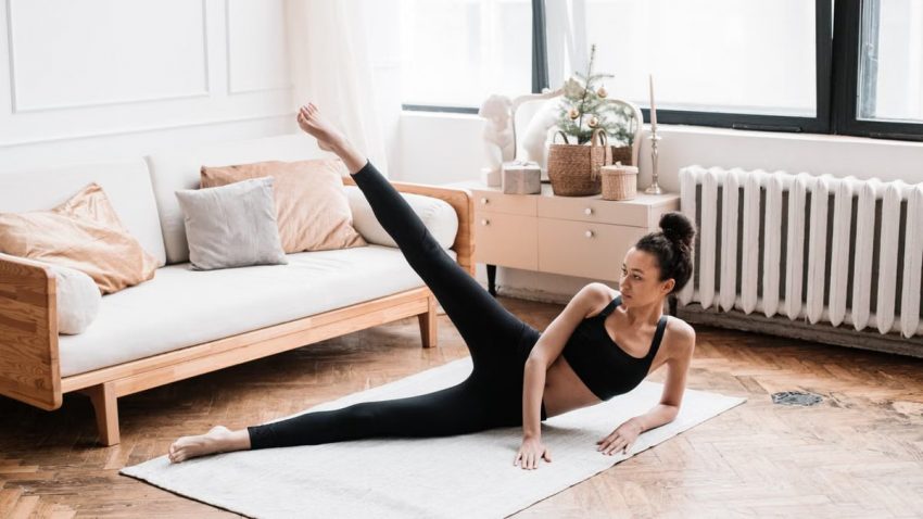 A woman exercises, performing yoga in a stylish living room with soft natural lighting.